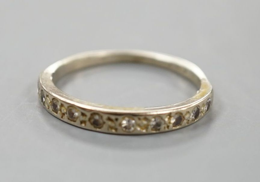 A white metal and diamond chip set half eternity ring, size K